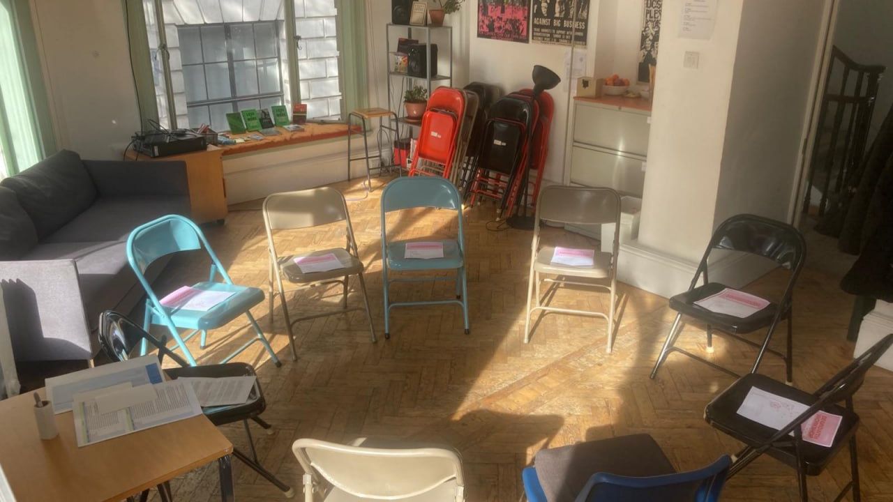Picture of chairs assembled in a circle, inside a workshop room. Sunlight pours through the window