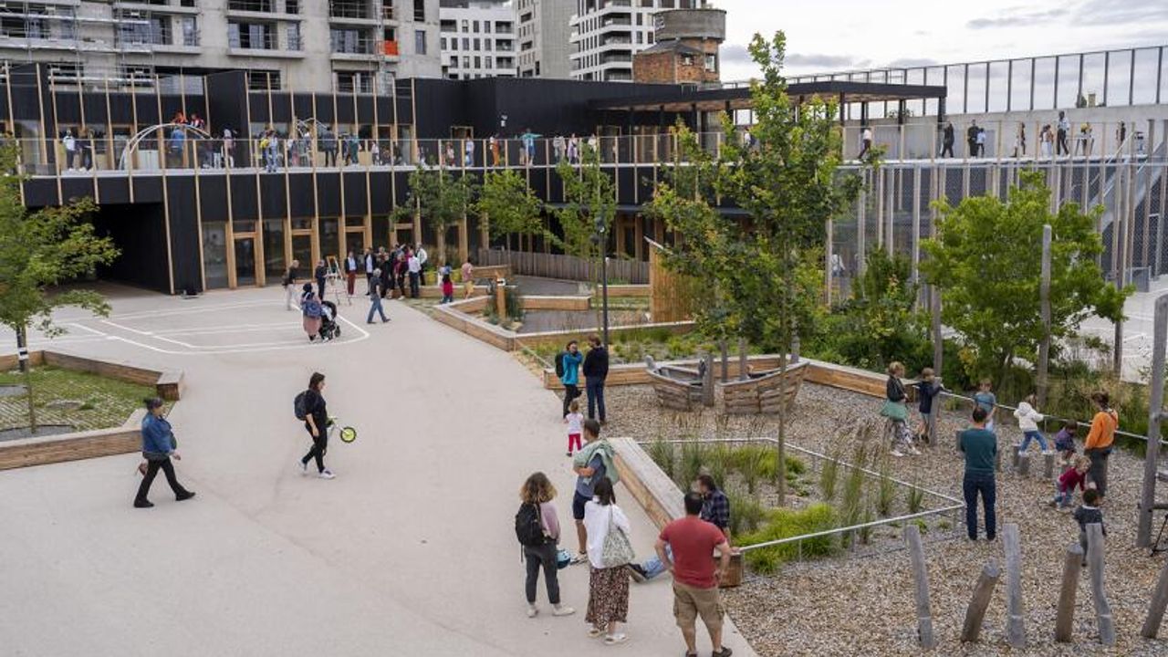 Des enfants et leurs parents découvrent la cour de récréation du groupe scolaire Miriam-Makeba
