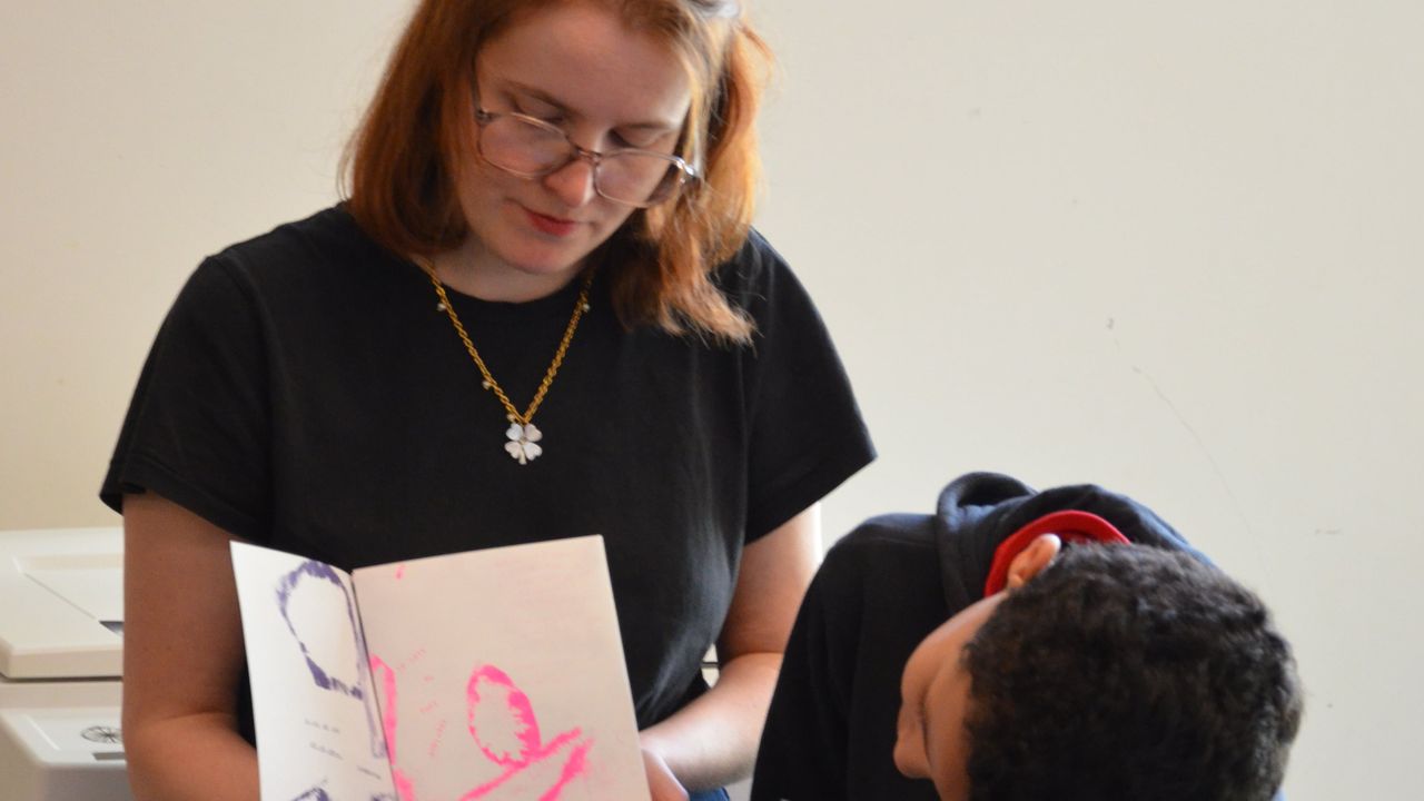 Margaux Janisset montre le fanzine tout juste imprimé et découpé à un des élèves