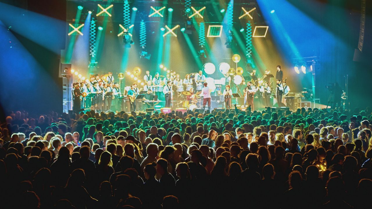 Une foule assemblée devant un bagad qui se produit sur scène.