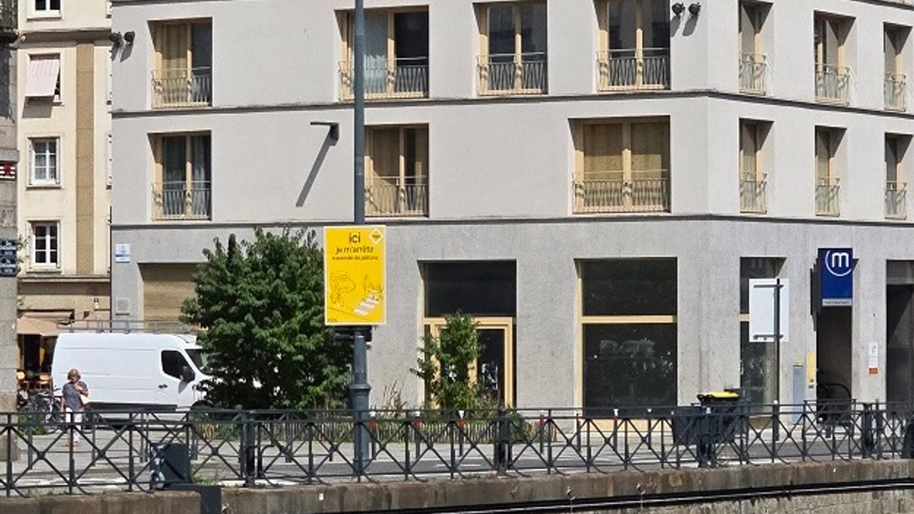 Un panneau de la campagne partage de la rue place Saint-Germain, il est inscrit "Ici je ralentis, présence de piétons"