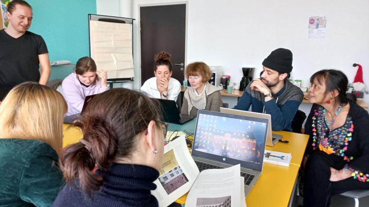 Les nouveaux commissaires travaillent devant des ordinateurs et parcourent des documents imprimés.