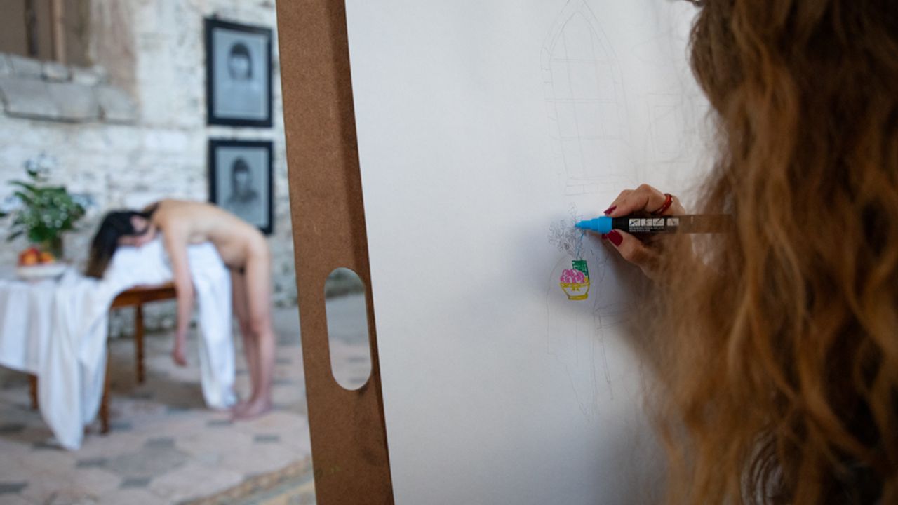 Une femme dessine un portrait de nue