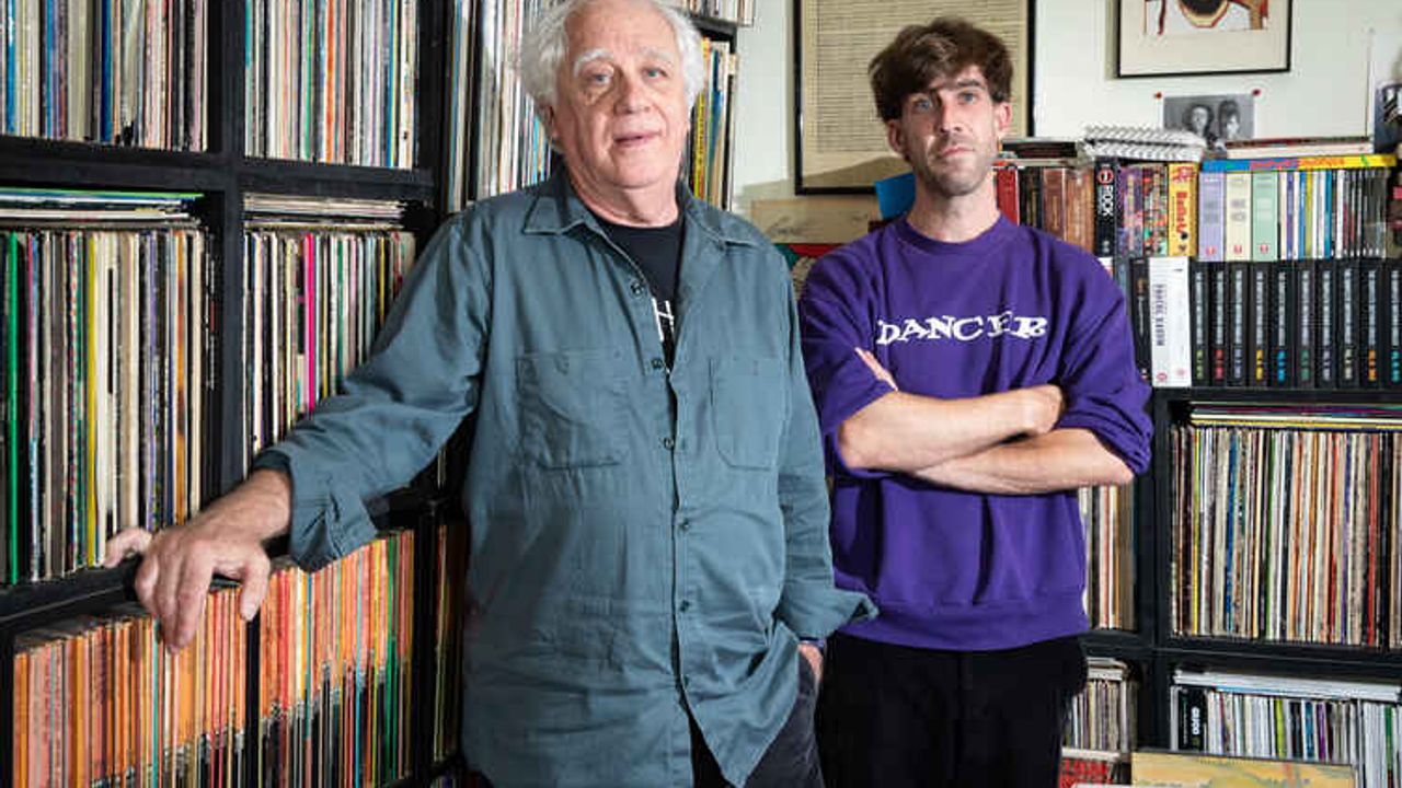 Les programmateurs Jean-Louis Brossard et Théo Muller debout dans un bureau, devant des étagères remplies de disques vinyles