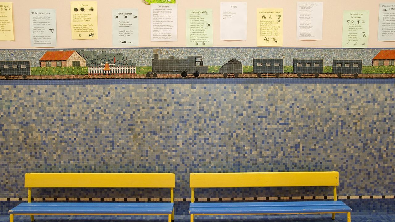 Deux bancs devant un mur décoré par Odorico à l'intérieur de la crèche Papu.