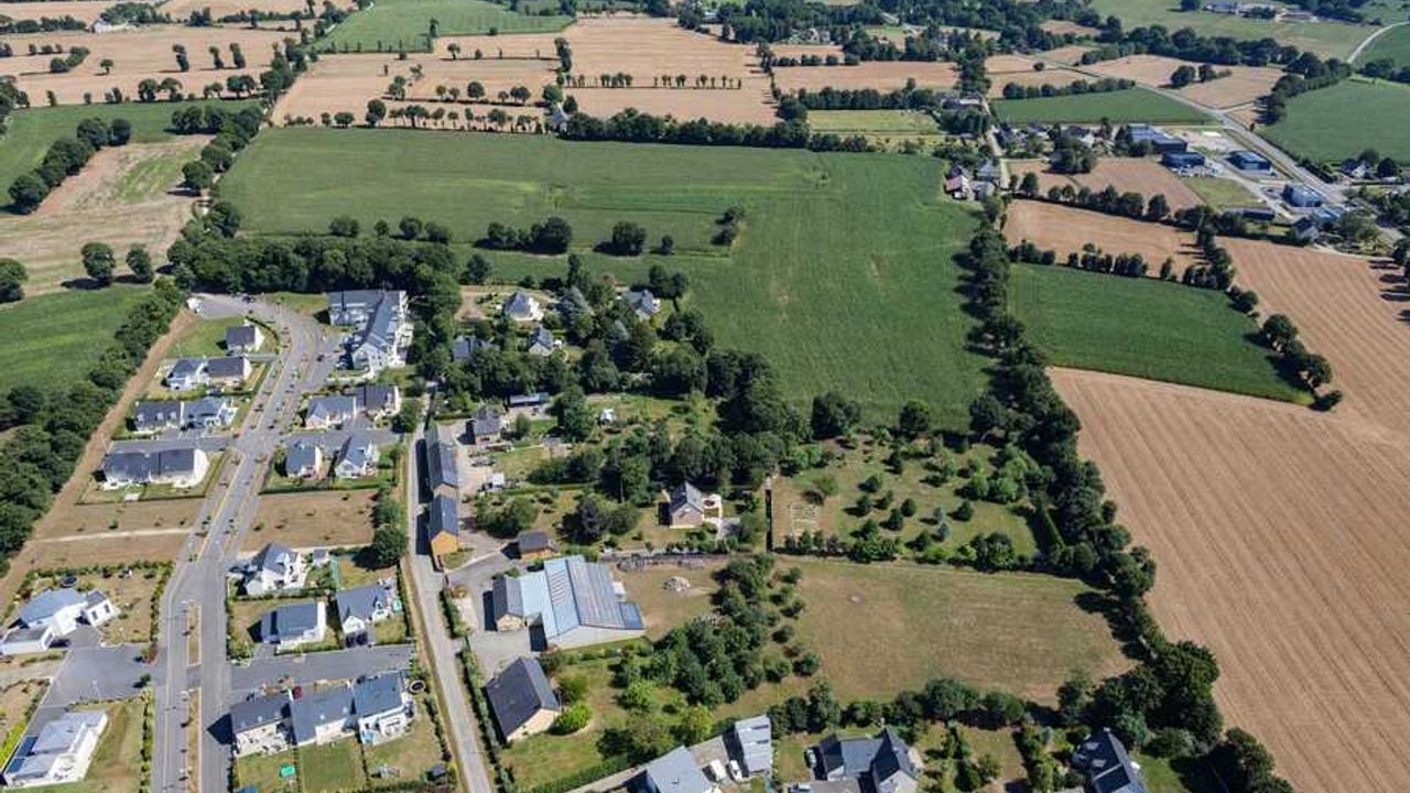 Vue aérienne de la commune de Gévezé. Au premier plan, des lotissements de maisons, en arrière-plan les terres agricoles.