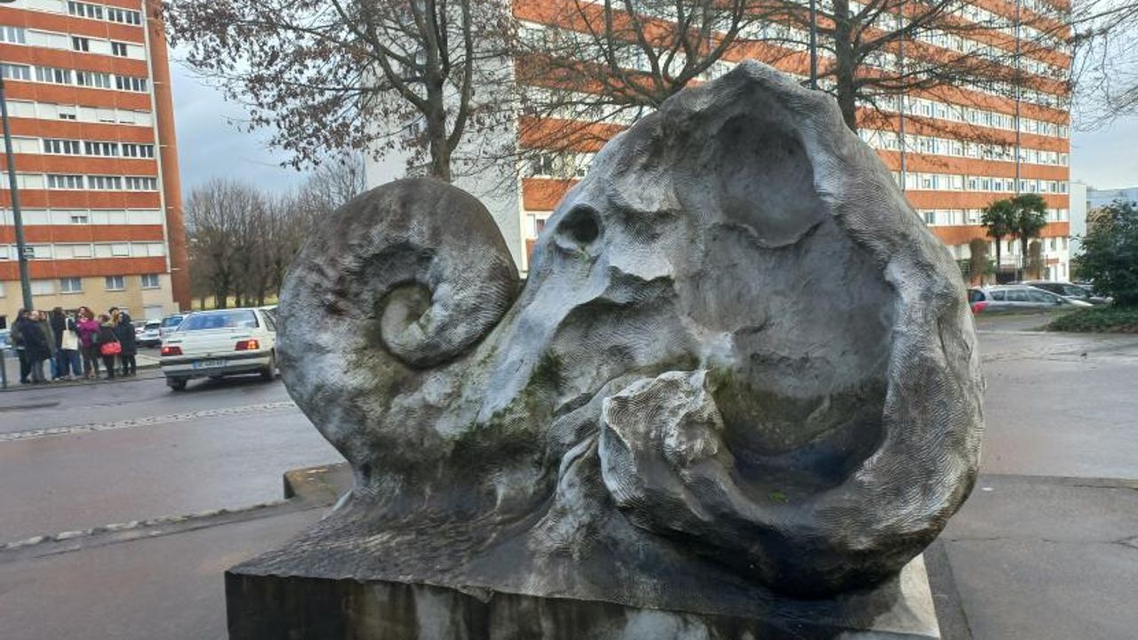 Au premier plan, la sculpture Janus, oeuvre de Peter Briggs et à l'arrière-plan, des tours d'immeubles de Bréquigny