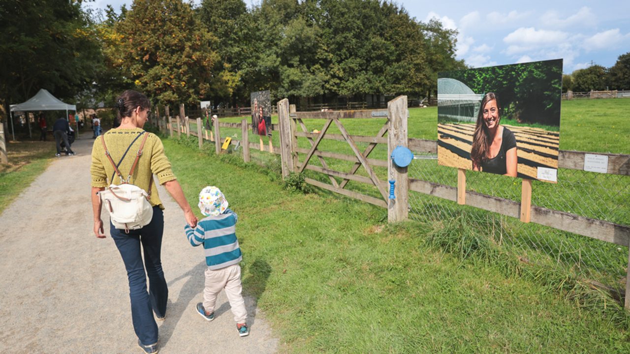 Promenade d’une femme avec un enfant en bas âge, le long des espaces de pâturage.