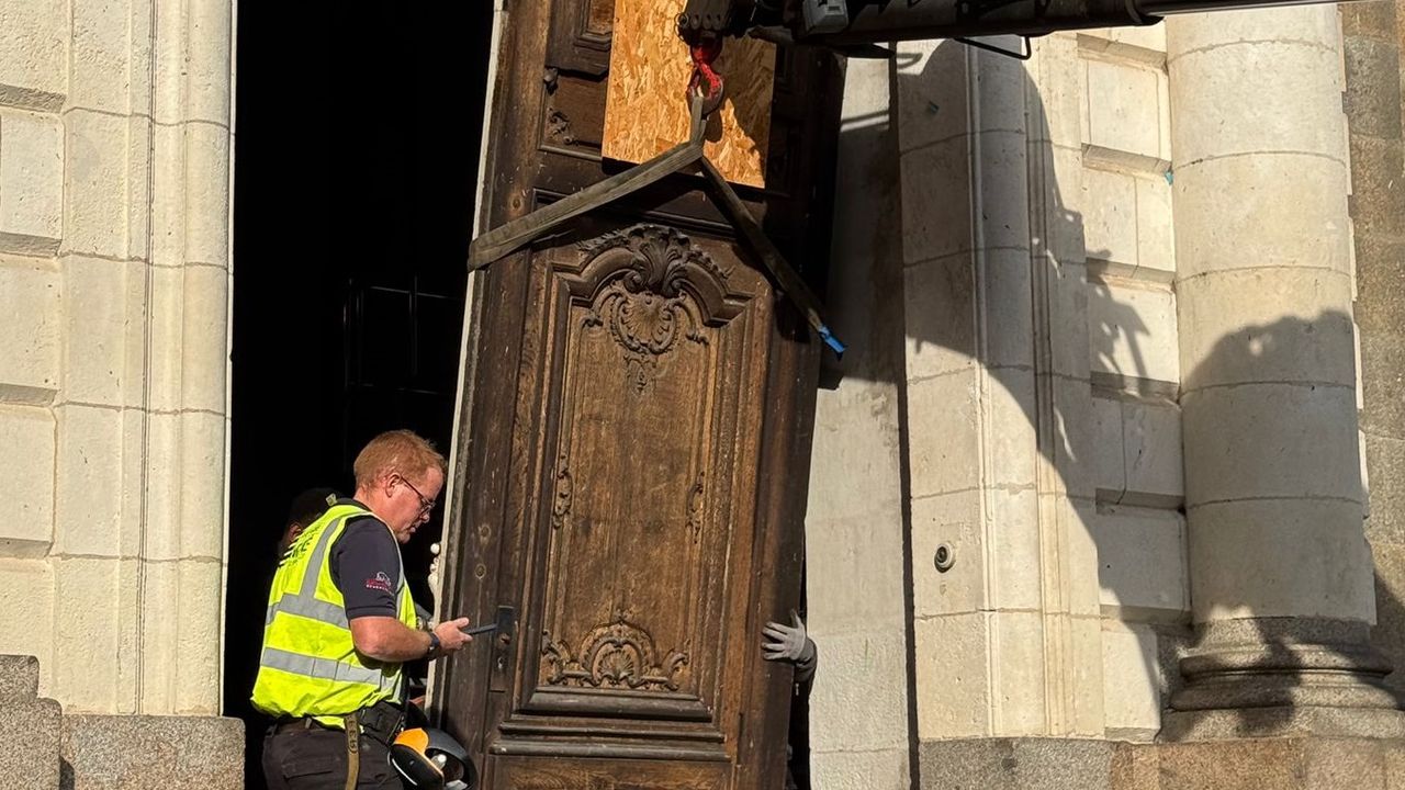 Un agent de maintenance soulève la porte cochère à l'aide d'une machine