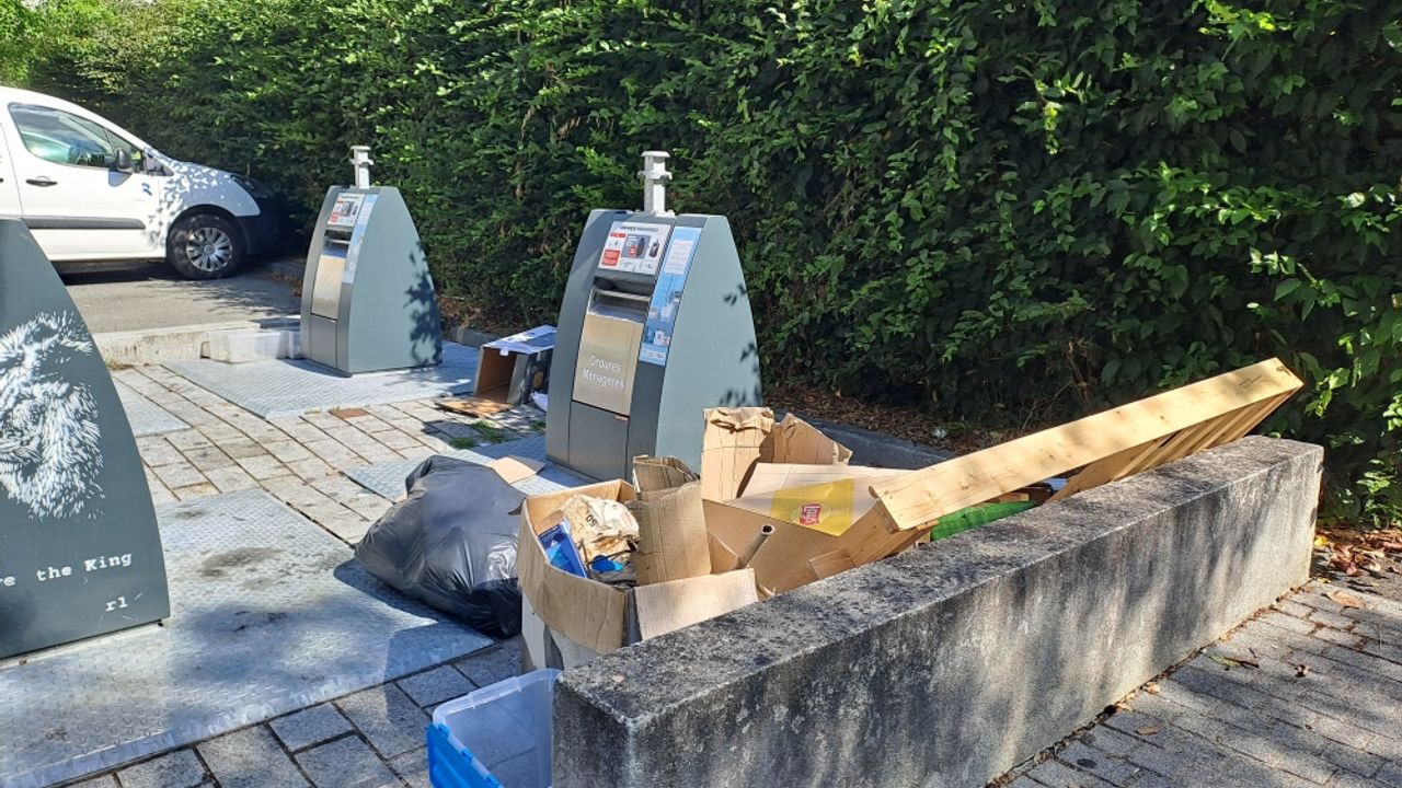 Objets divers au pied d'un point d'apport volontaire de déchets.