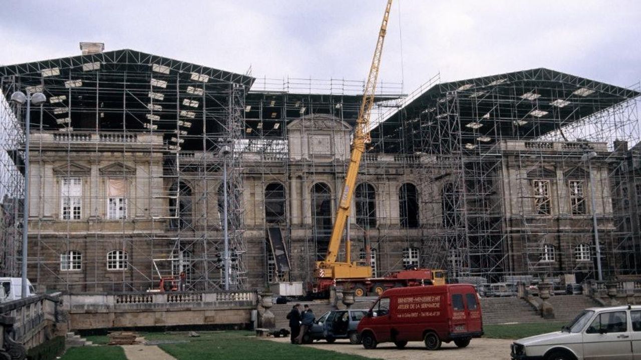 Vue sur le Parlement après l'incendie avec des échafaudages et un toit de tôles en métal.