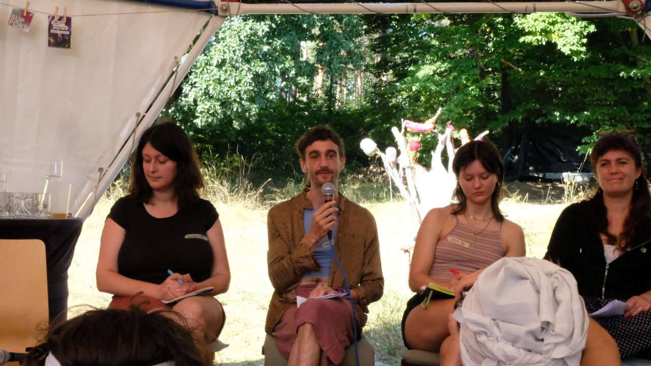 People sitting on a stage talking at a roundtable