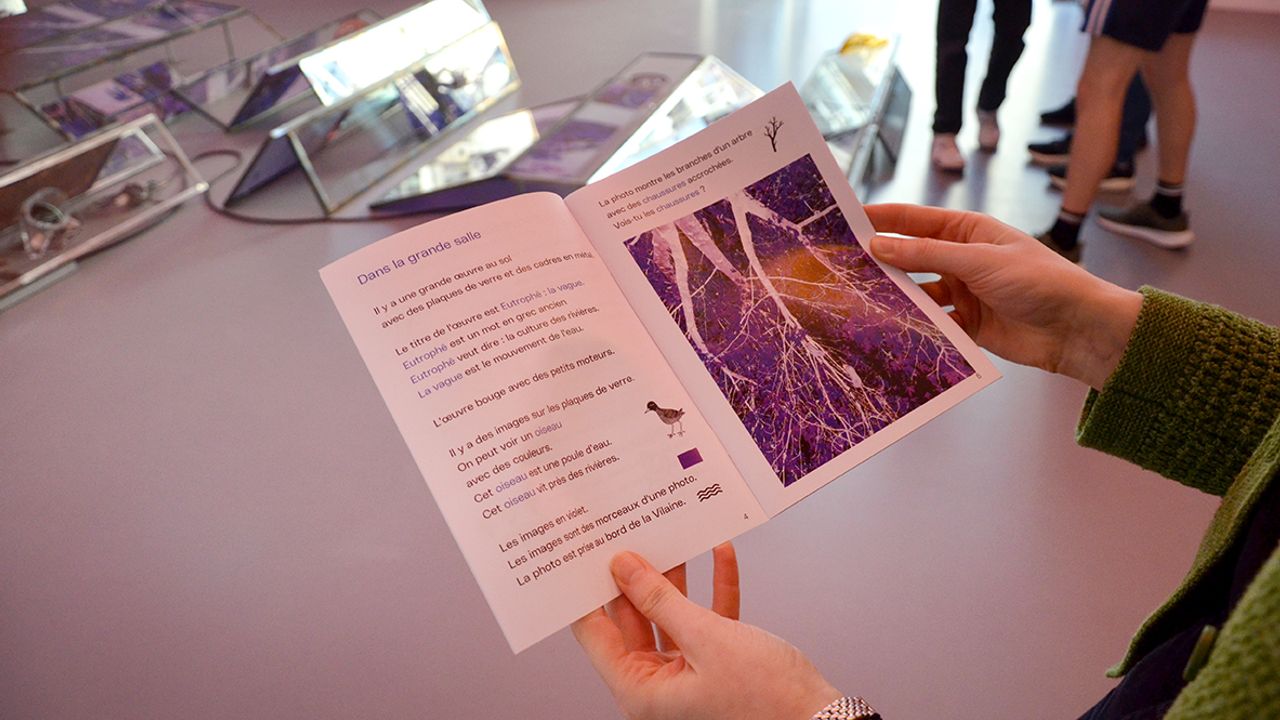 Une femme tient le livret FALC dans ses mains