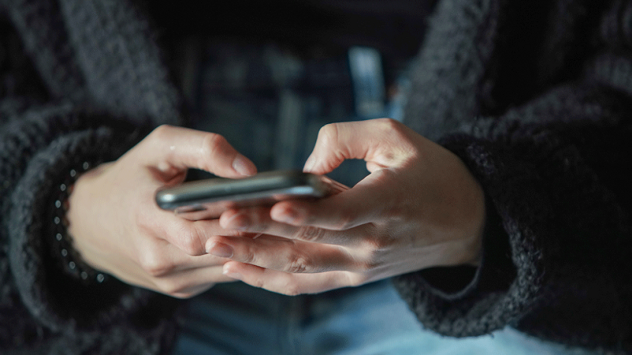 gros plan sur deux mains qui tiennent un téléphone portable