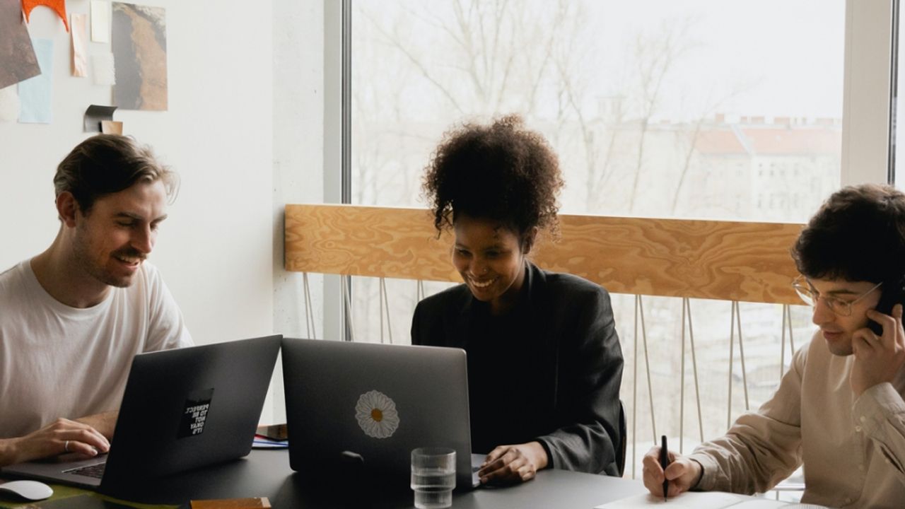 Trois personnes en train de travailler en réunion