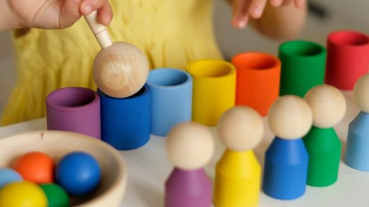 Un jeune enfant manipule des jeux en bois de motricité.