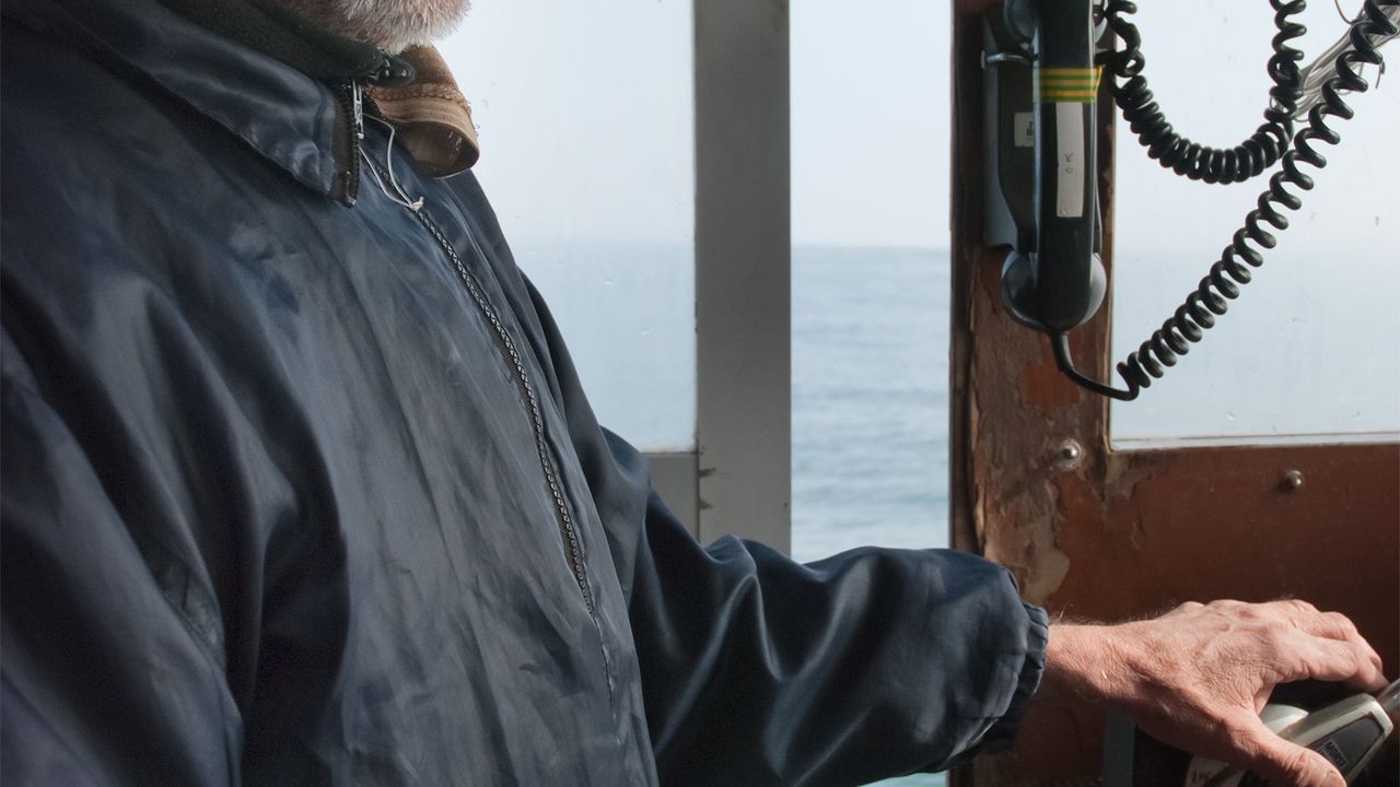 Portrait pêcheur avec son béret au volant de son bâteau