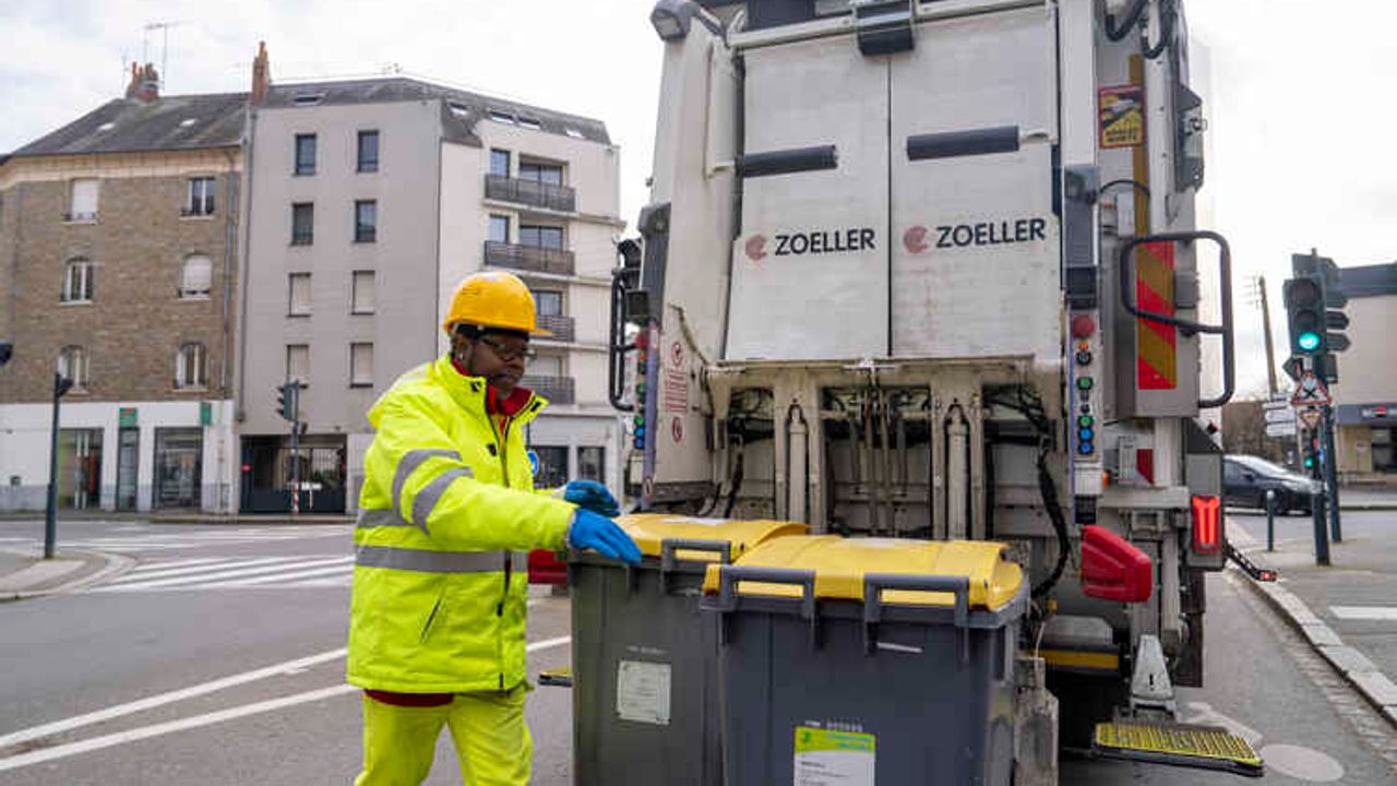un ripper déplace des bacs de collecte de déchets recyclables dans une rue de rennes