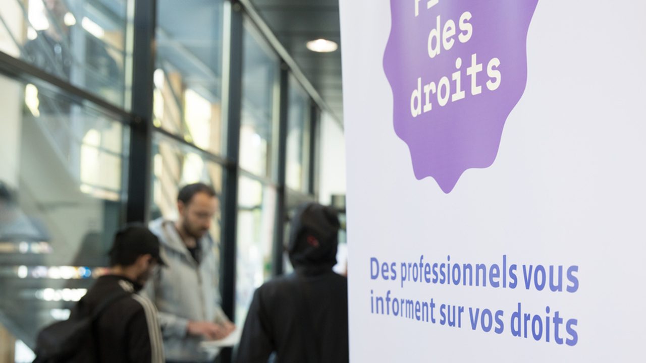 Des jeunes participent à une réunion d’information sur leurs droits. En premier plan, un panneau d'information.