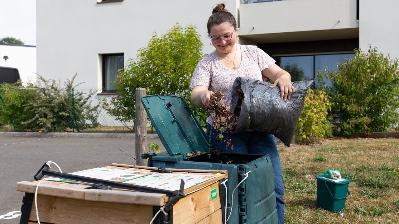 Amandine, habitante de Gévezé ajoute des feuilles mortes dans un composteur.