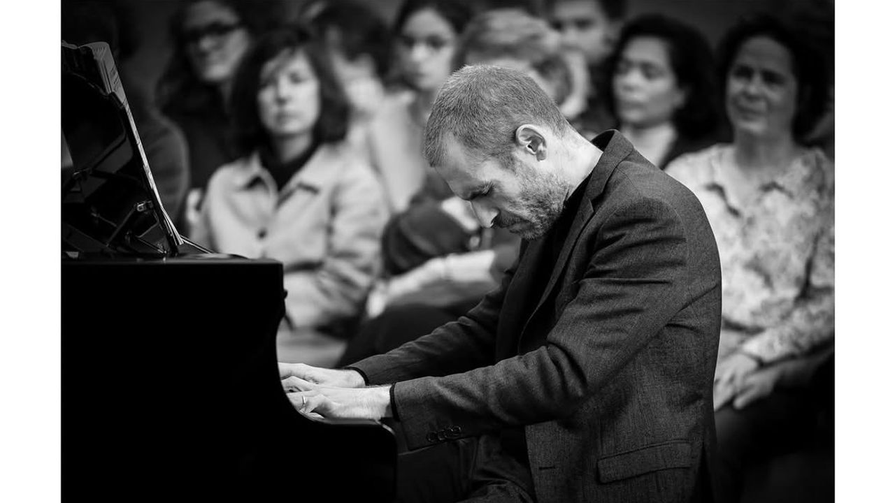 Melaine Dalibert jouant du piano, avec le public en arrière plan