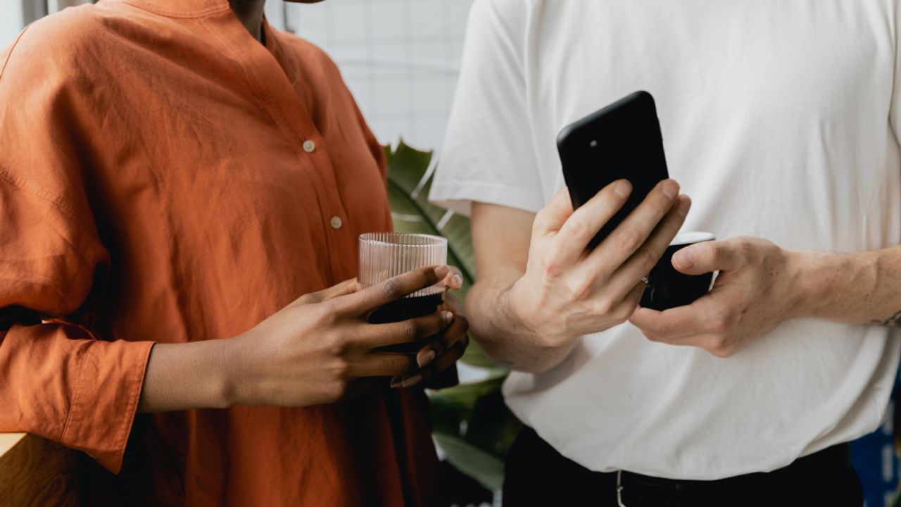 Personne montrant son téléphone portable à une autre personne