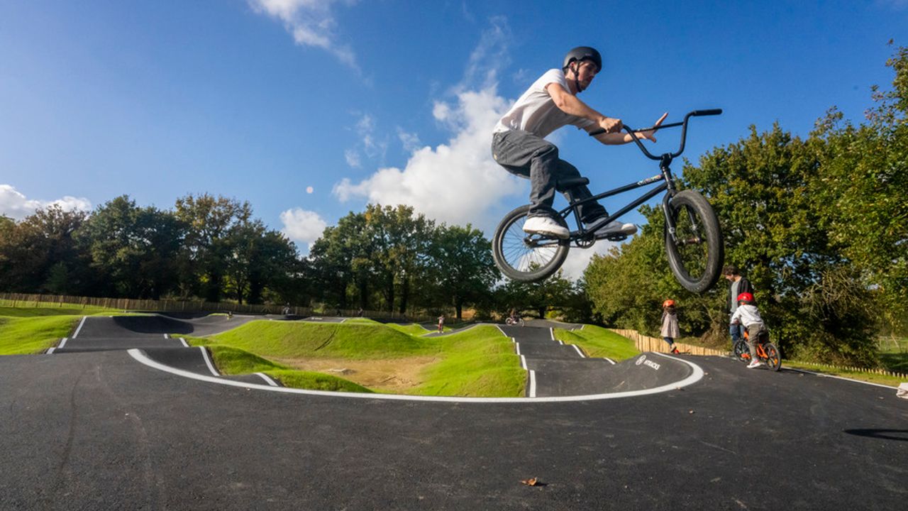 Un jeune fait une figure acrobatique en BMX.