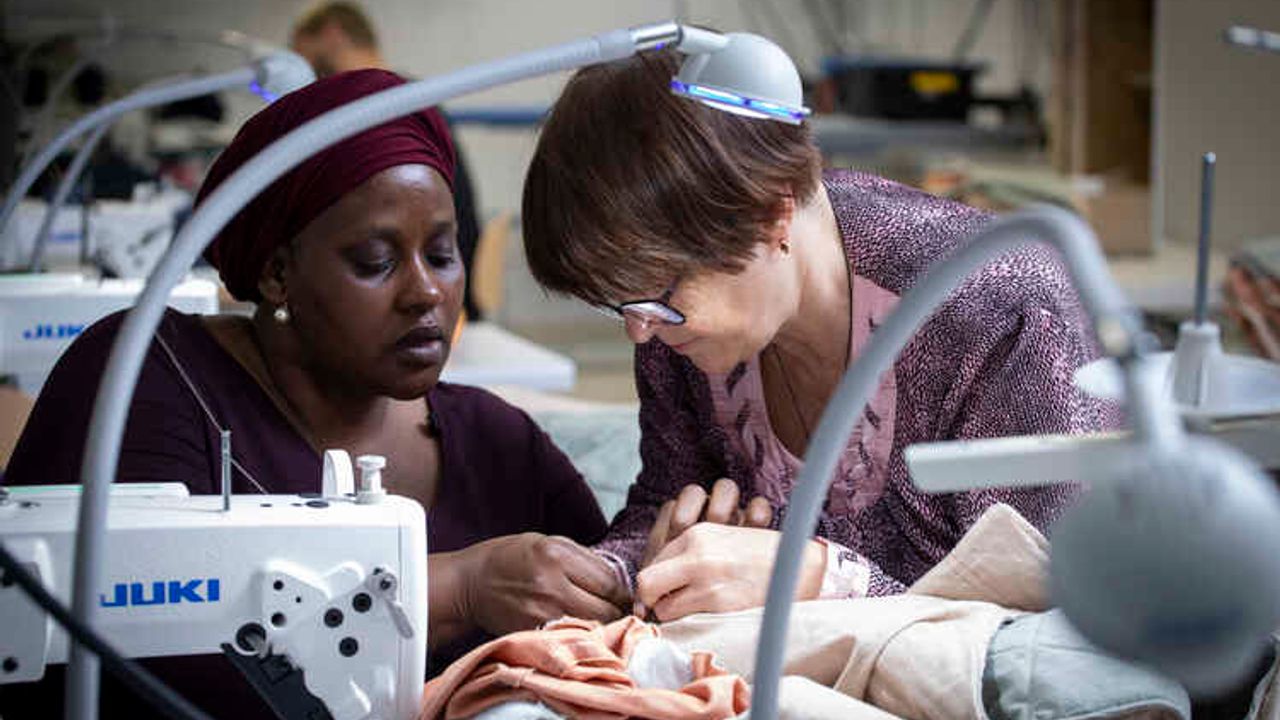 Une femme apprend la couture de réparation avec l'association Esperen