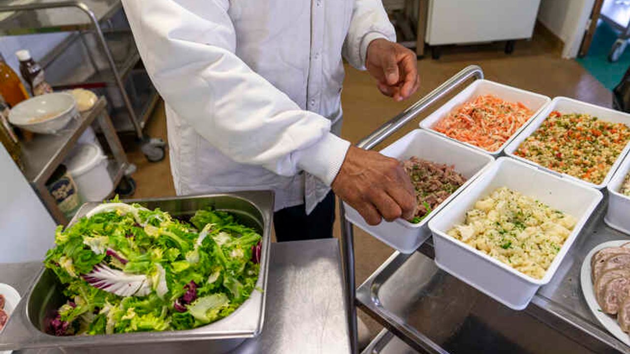 Un cuisinier prépare des entrées pour la restauration scolaire.