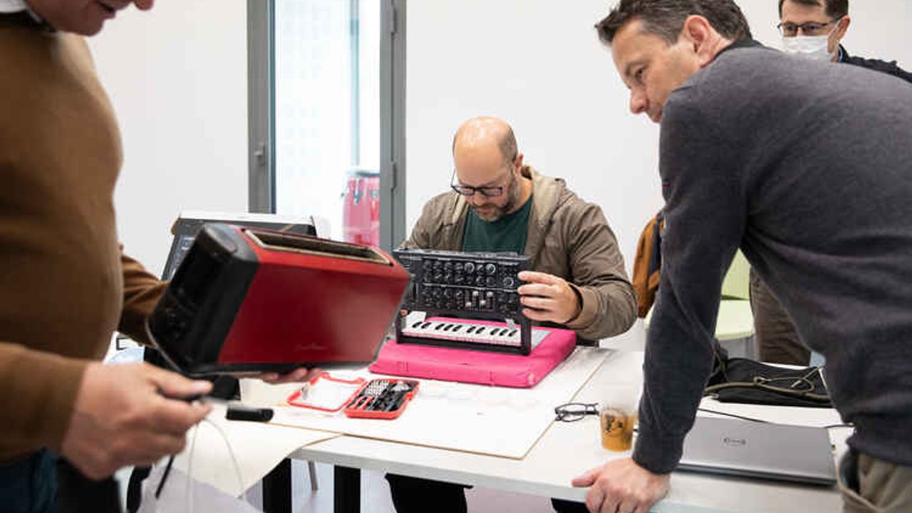 Les réparateurs bénévoles examinent un grille-pain et un synthétiseur défectueux.