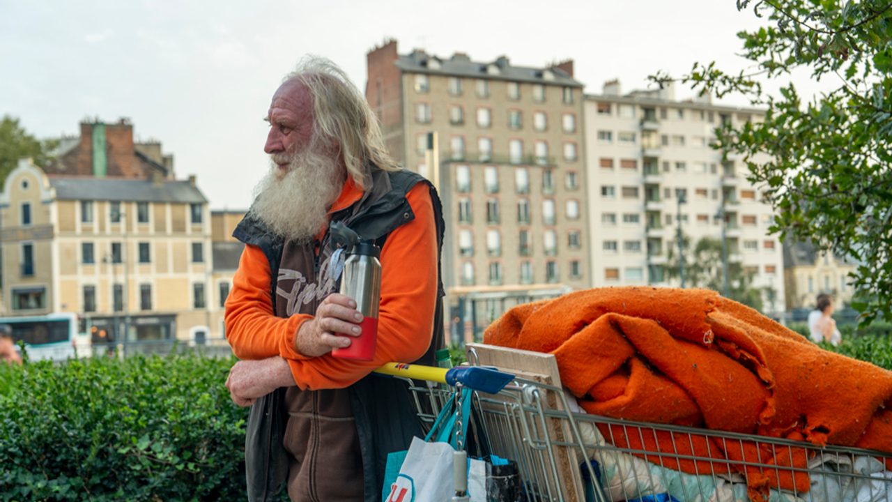 Homme sans domicile avec son caddie rempli d'affaires.