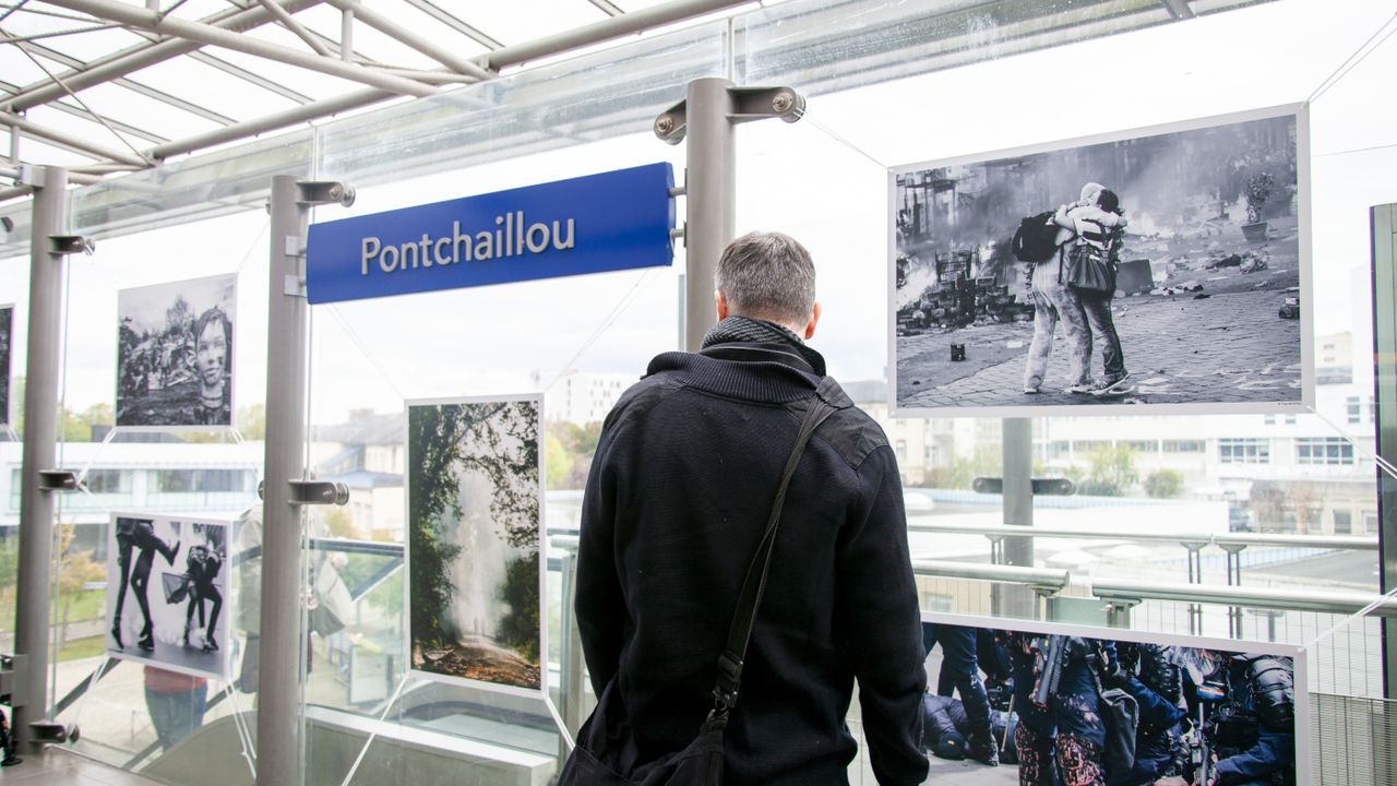 Une personne devant des photographies à la station de métro Pontchaillou