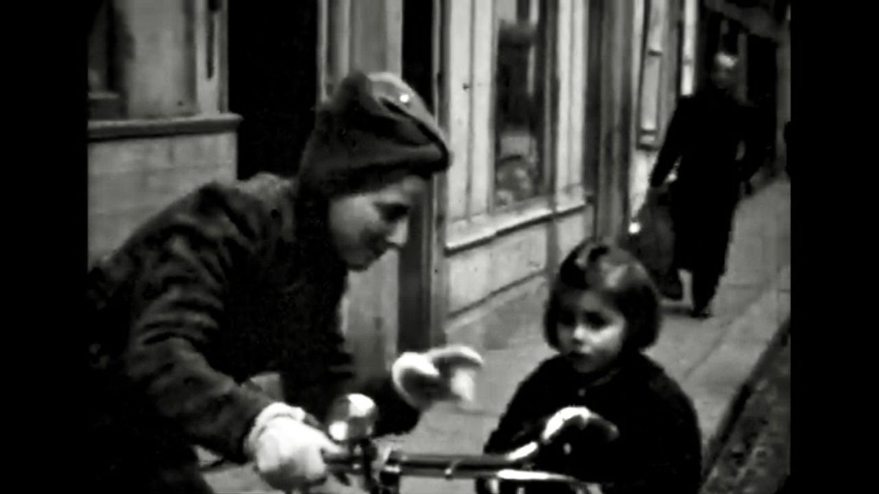 Une maman et sa fille qui arrivent en vélo - Photo d'époque en noir et blanc