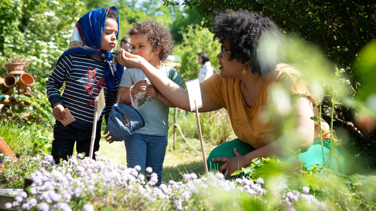 Des enfants et une femme qui sentent les plantes aromatiques