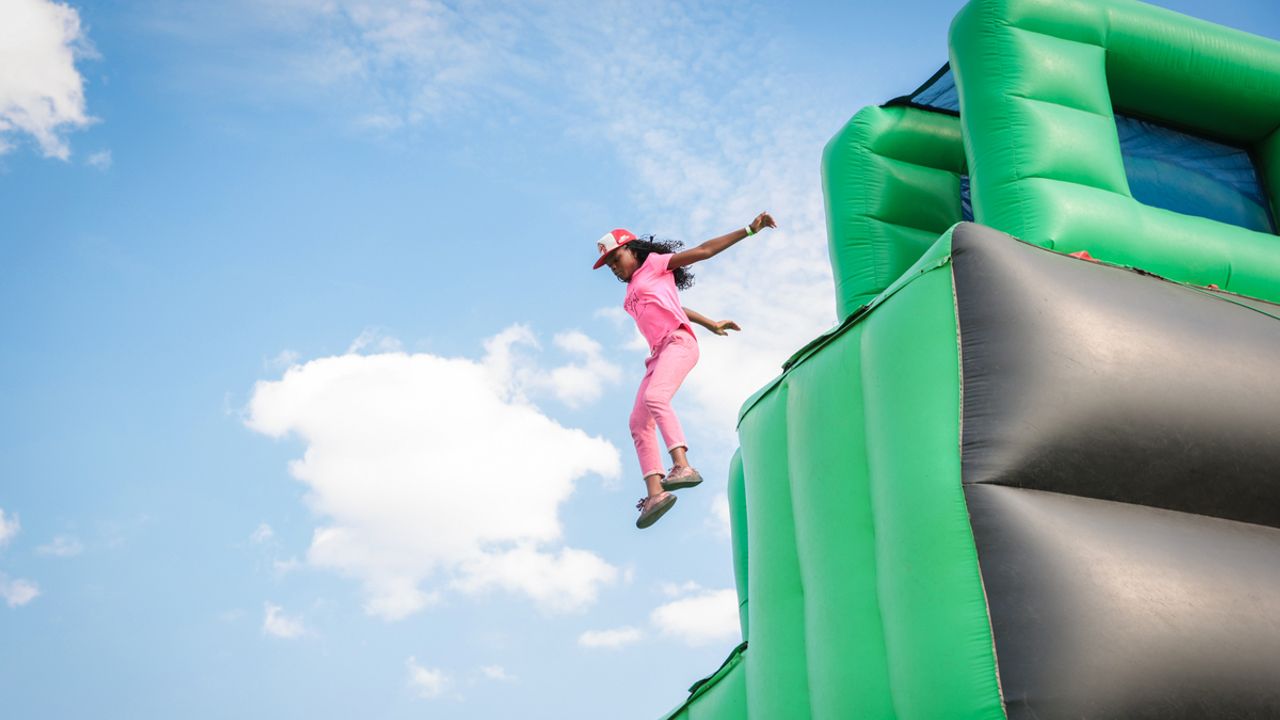 Jeune fille qui saute d'une structure gonflable