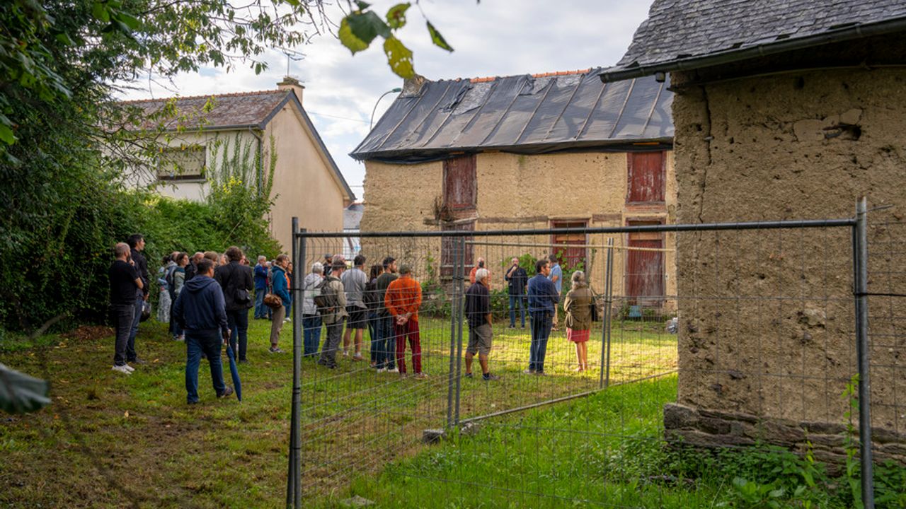 Un groupe de personnes devant des bâtiments anciens en visite.