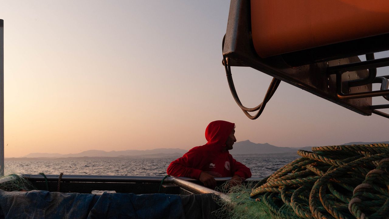 Pêcheur regard au loin devant des filets de pêche