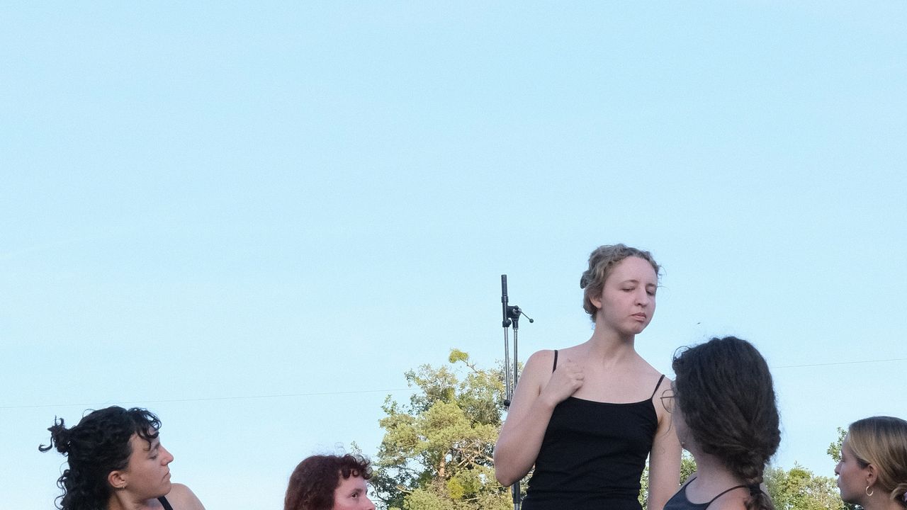 People performing on a stage outside during golden hour