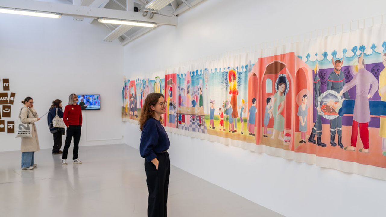 Le public contemple une large fresque colorée