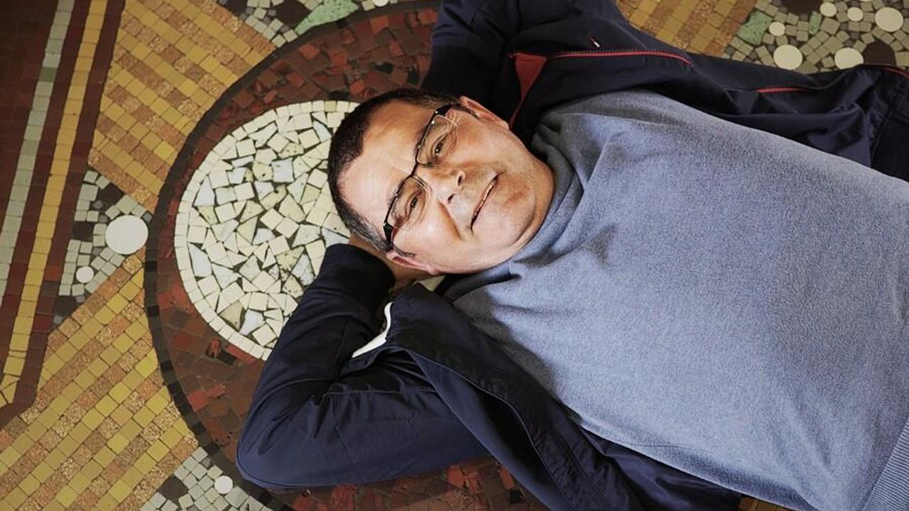 Portrait de Daniel Enoch allongé au sol, sur une mosaïque Odorico