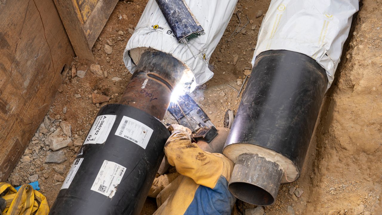 Un ouvrier met en place les tuyaux du réseau de chaleur urbain.