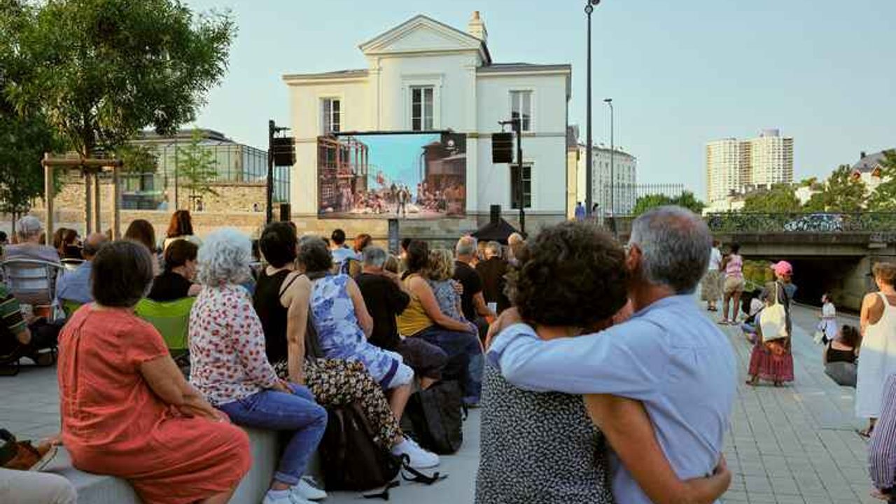 des personnes assistent à un opéra sur écran en extérieur à Rennes sur les quais.