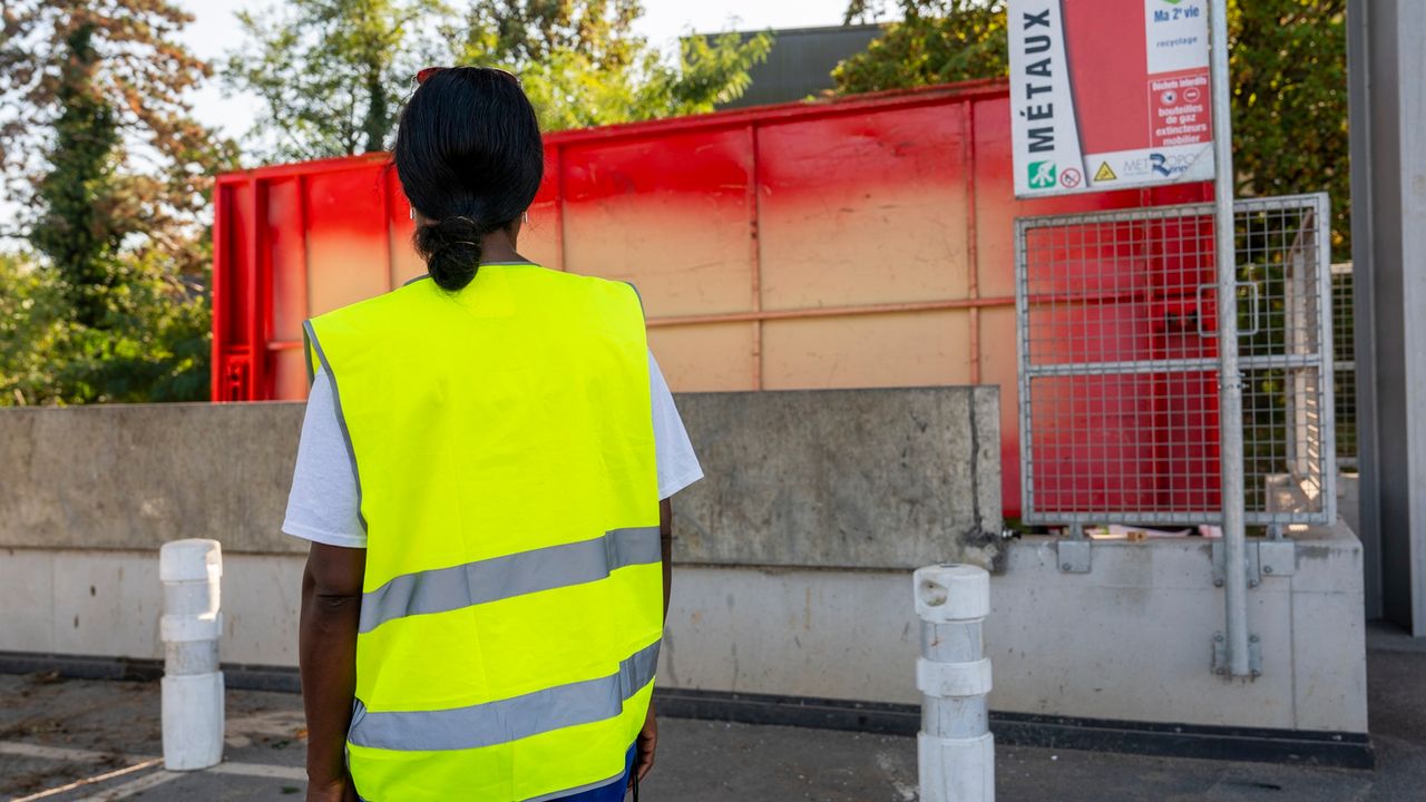Agent de déchèterie de dos face à une benne de collecte.