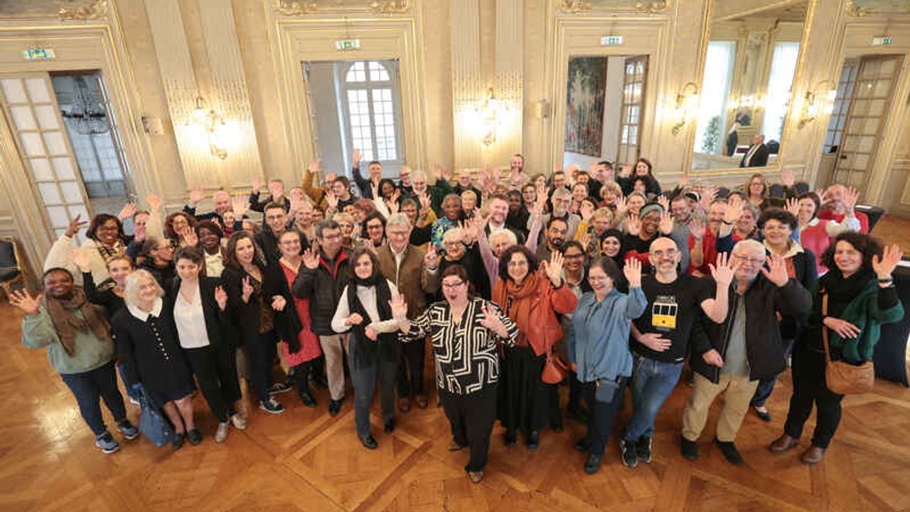 Les personnes réunies dans les grand salons de l'Hôtel de Ville à Rennes prennent la pose pour la photo.