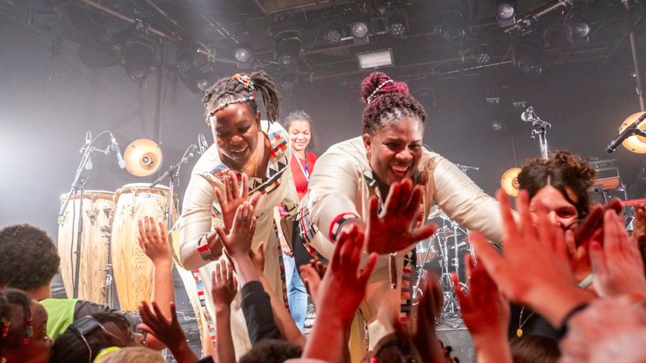 des femmes artistes sur scène viennent frapper dans les mains du public