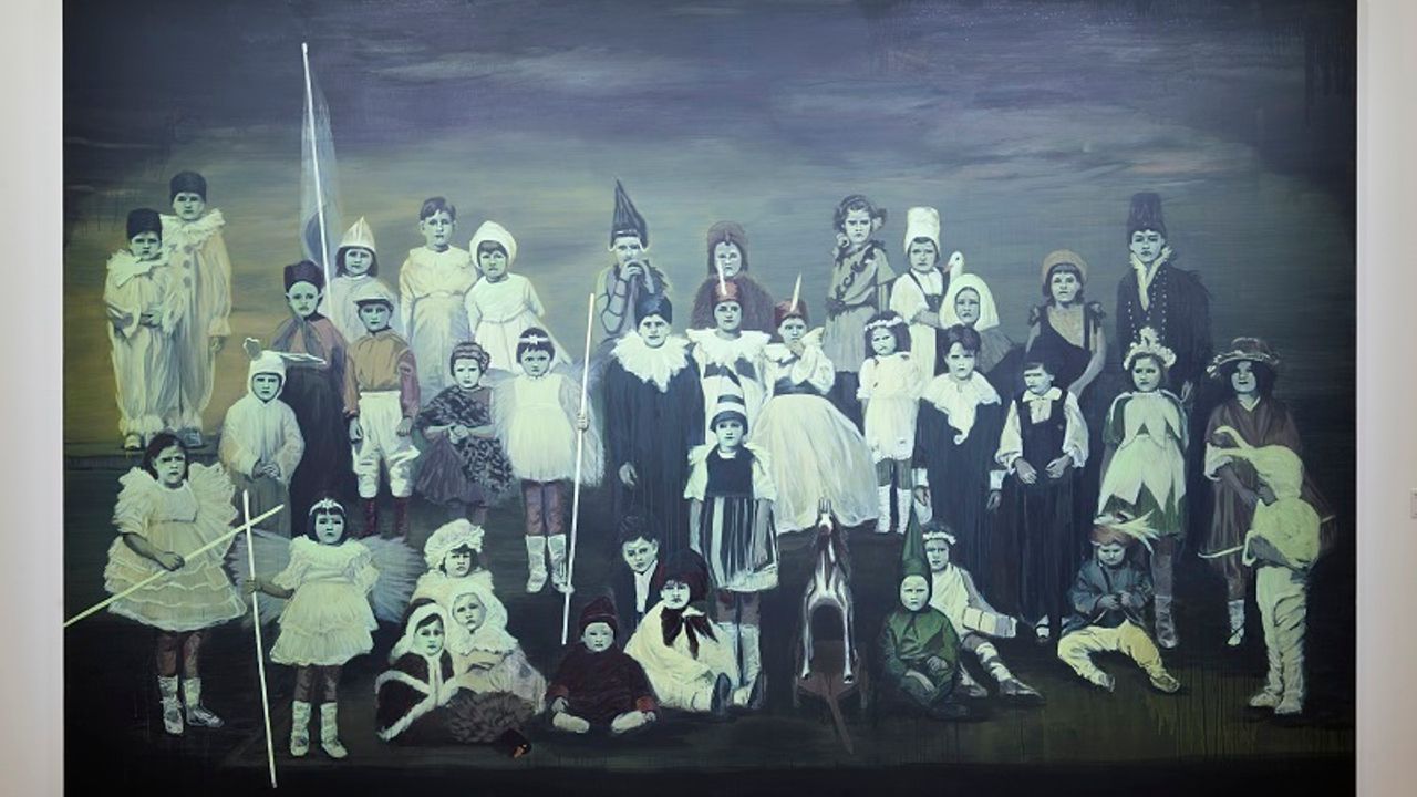 Des enfants en costumes sont peints sur un grand tableau.