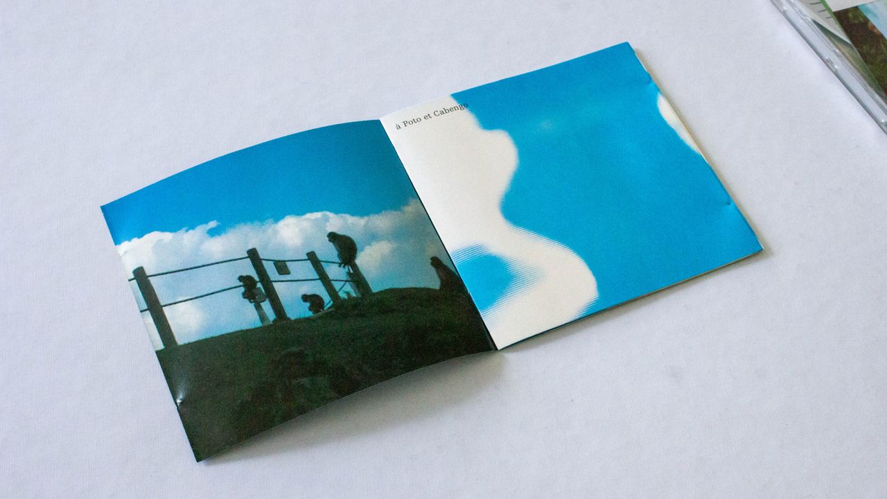 Livret ouvert en deux volets où l'on voit deux images. A gauche une vue du ciel prise depuis le sol. On voit de l'herbe et une barrière comme celle qui délimite un champ sur toute la partie basse de l'image. 3 personnes sont assis sur cette barrière et regarde le ciel. A droite, un gros plan sur ce qui semble etre le ciel et un nuage avec la mention en haut à gauche de la page carré "à Poto et Cabengo"