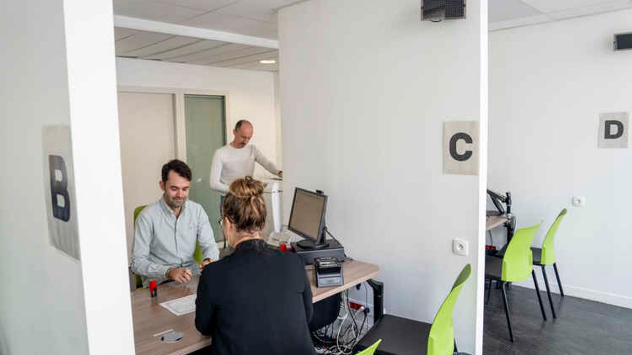 Une femme est reçu dans un bureau de l'état civil pour obtenir un certificat.