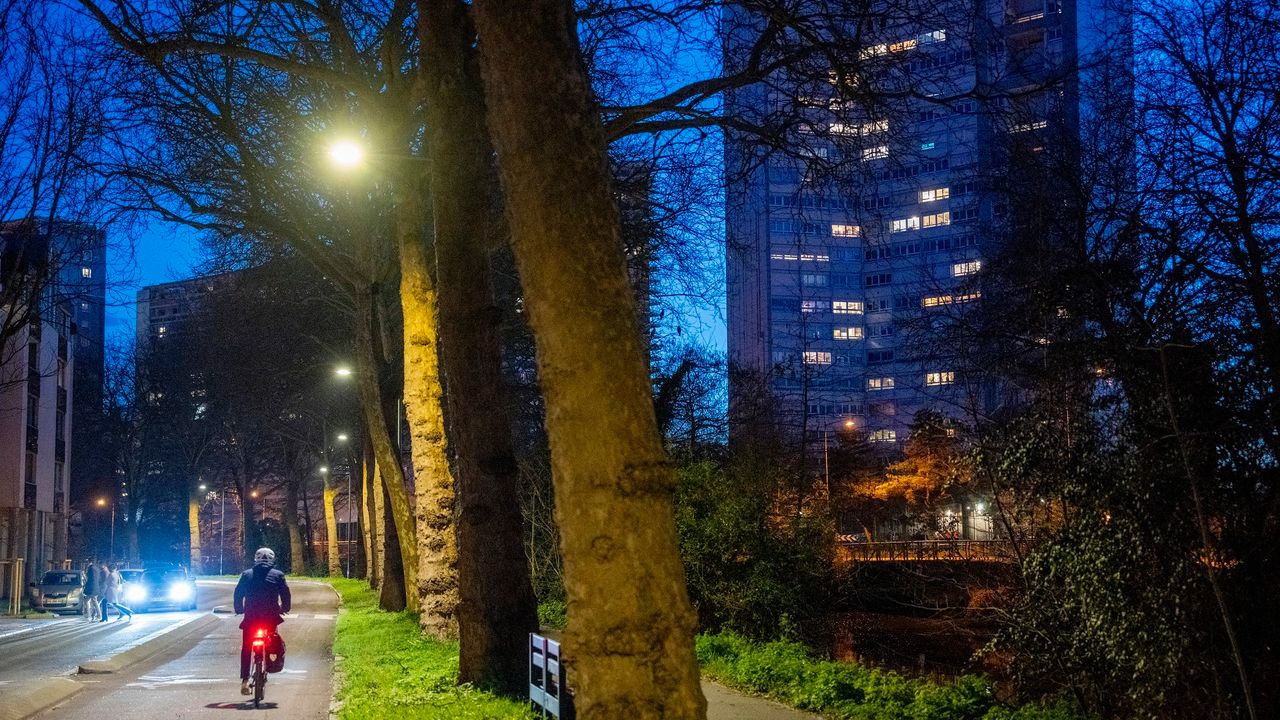 Photo d’une rue de Rennes, il fait nuit, l’éclairage public fonctionne, un cycliste passe sous un réverbère.