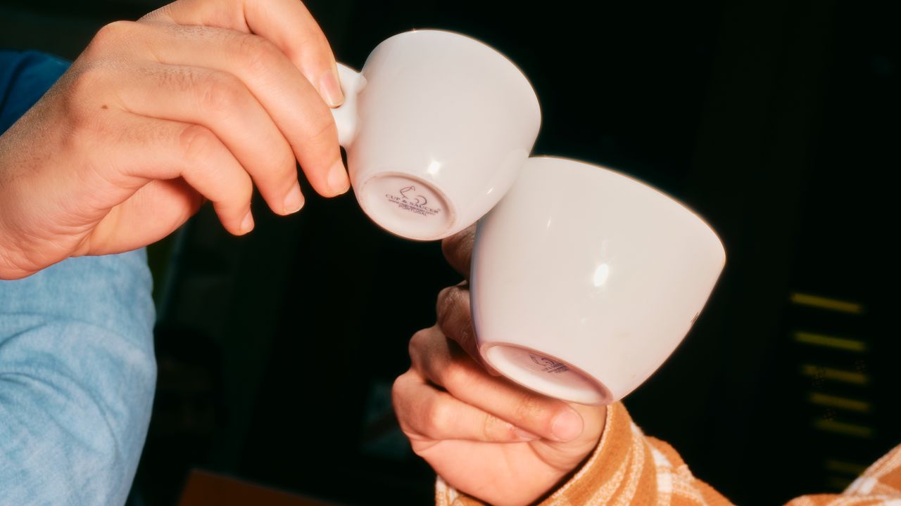 Deux personnes trinquent avec leur café